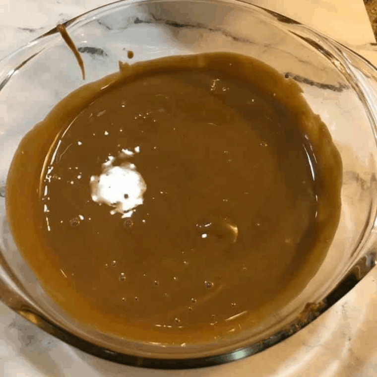 Heating cookie butter in a microwave-safe bowl until smooth, stirring frequently