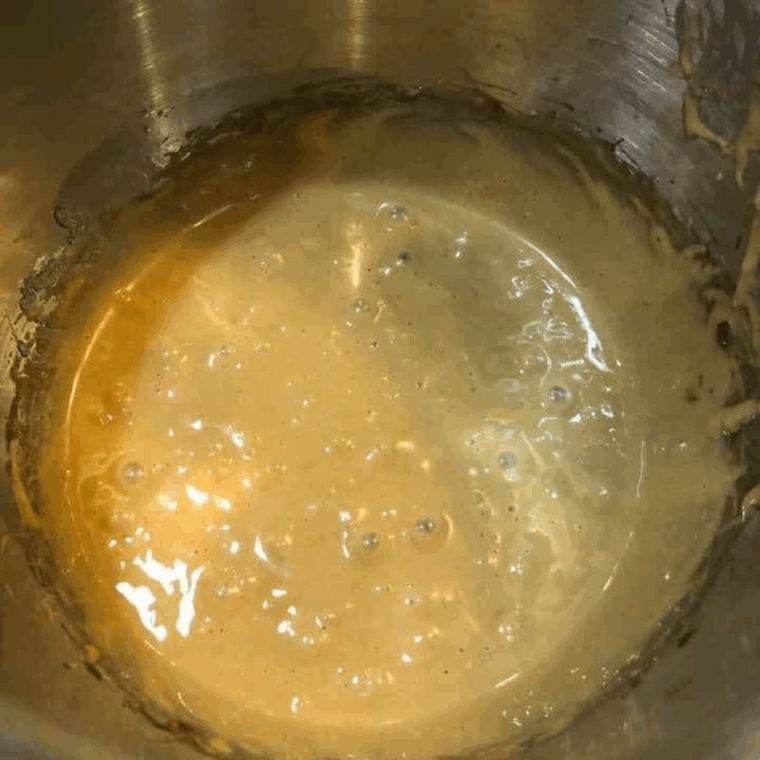 Mixing melted cookie butter, sugar, and eggs in a large bowl until creamy