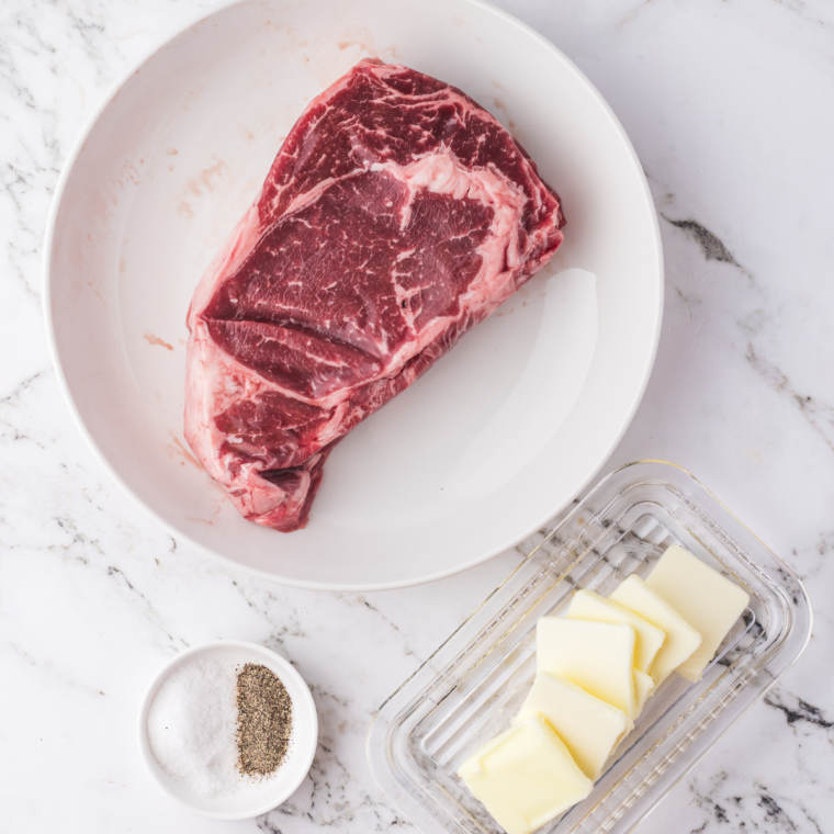 Seasoned frozen steak with olive oil, salt, pepper, garlic powder, and onion powder before air frying.