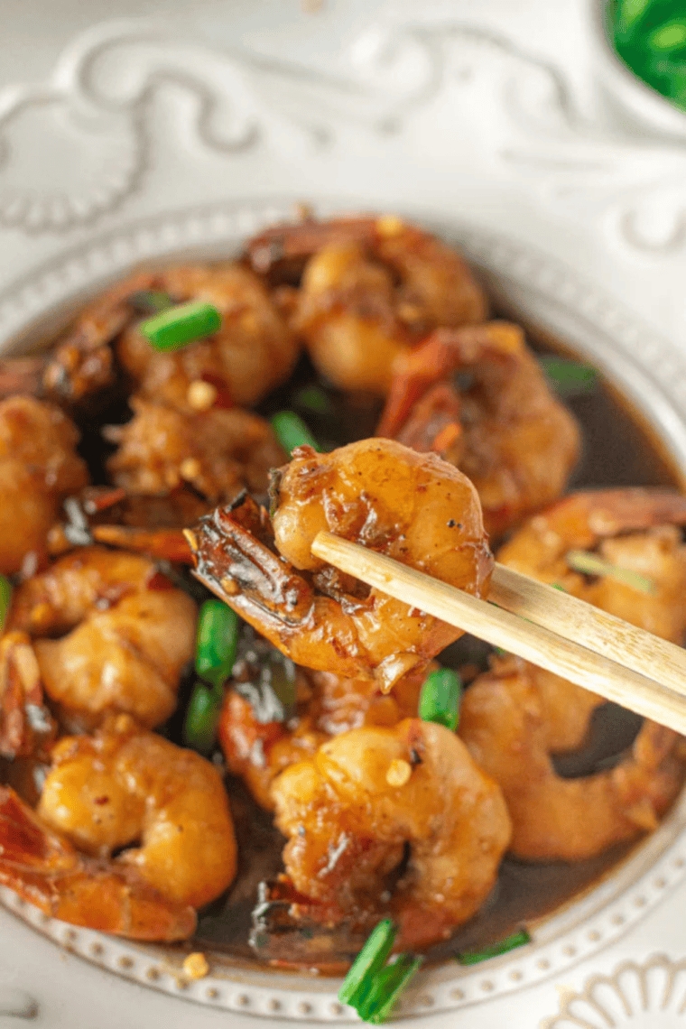 Sticky air fryer honey garlic shrimp fresh out of the air fryer, garnished with scallions
