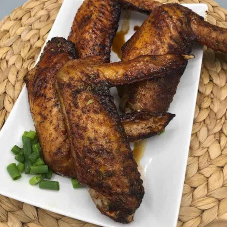 glazed turkey wings resting on a plate after air frying with caramelized coating