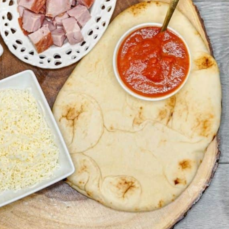 Ingredients needed for Air Fryer Naan Buffalo Chicken Pizza on kitchen table.
