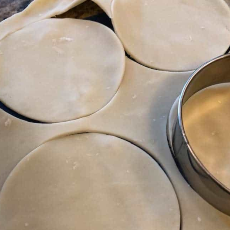 Rolling out puff pastry for Air Fryer Pecan Pie Hand Pies on a floured surface