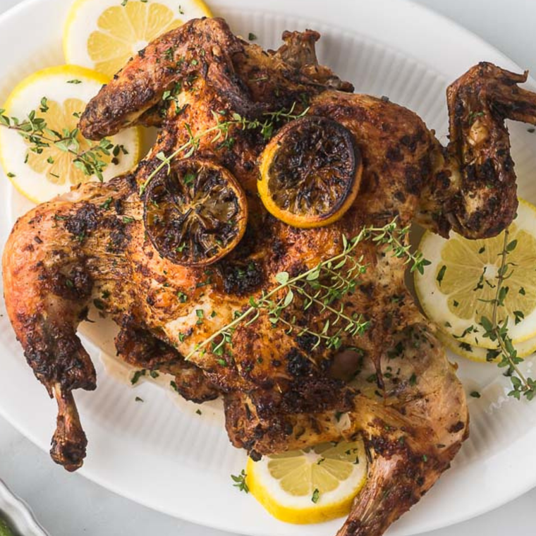 Air fryer spatchcock chicken on a plate with crispy golden skin