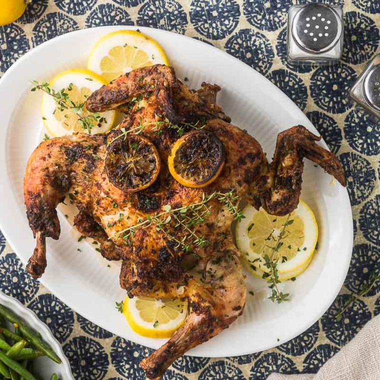 Juicy air fried spatchcock chicken served on a dinner plate