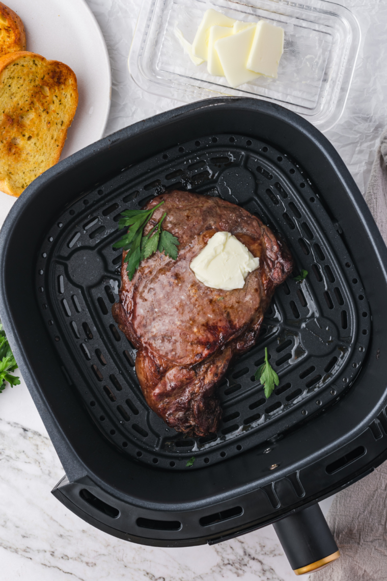 Using a meat thermometer to check the internal temperature of the steak for desired doneness.