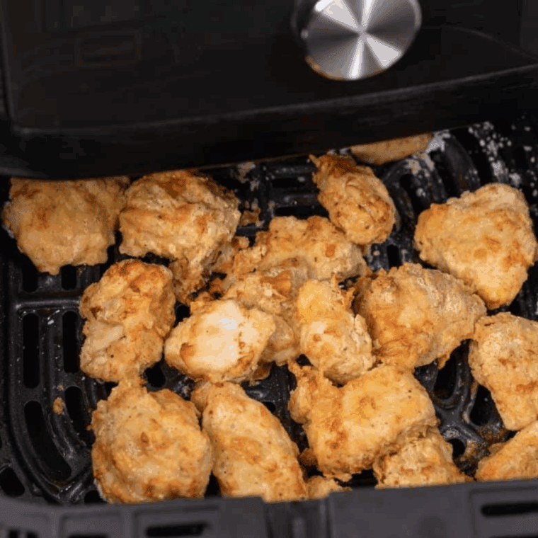 Cooked chicken in the air fryer basket.