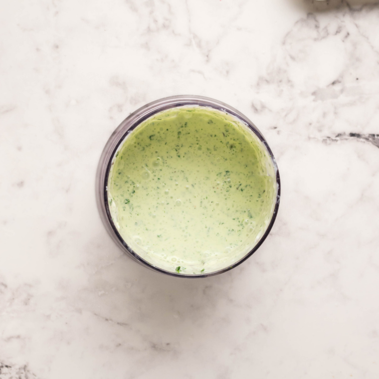 Cilantro lime sour cream ingredients blended in a food processor for air fryer taco cups