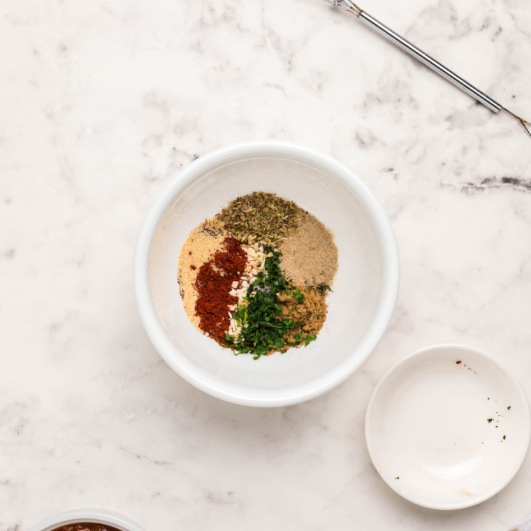 Homemade taco seasoning blend mixed in a small white bowl.