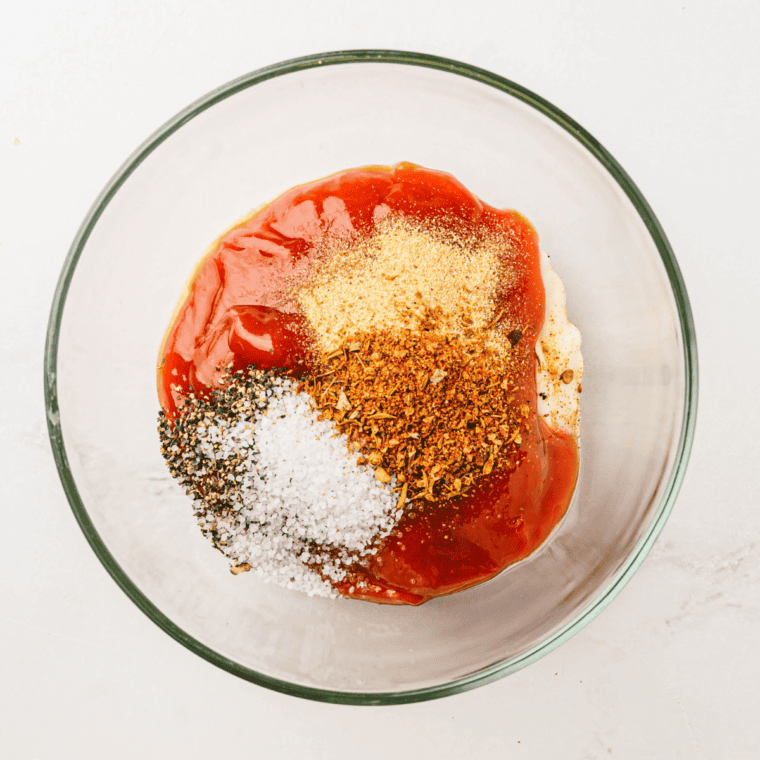 Adding all ingredients into a medium mixing bowl for sauce preparation