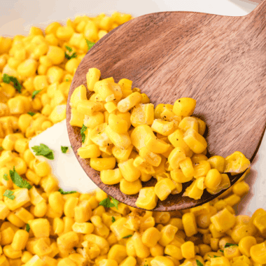Golden roasted frozen corn kernels cooked in the air fryer, served in a white bowl and ready to enjoy.