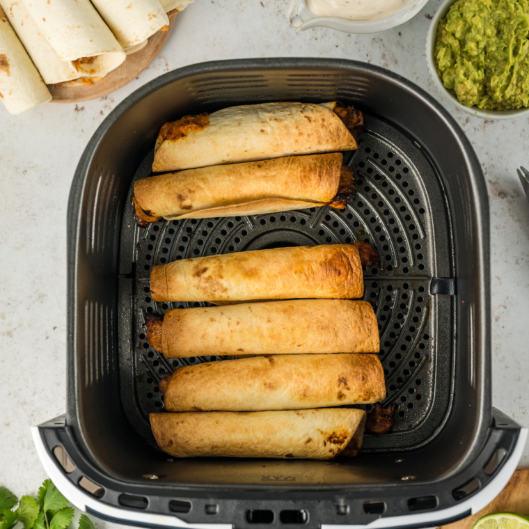 Plate of golden brown Air Fried Refried Bean and Veggie Flautas, ready to serve with dipping sauce.