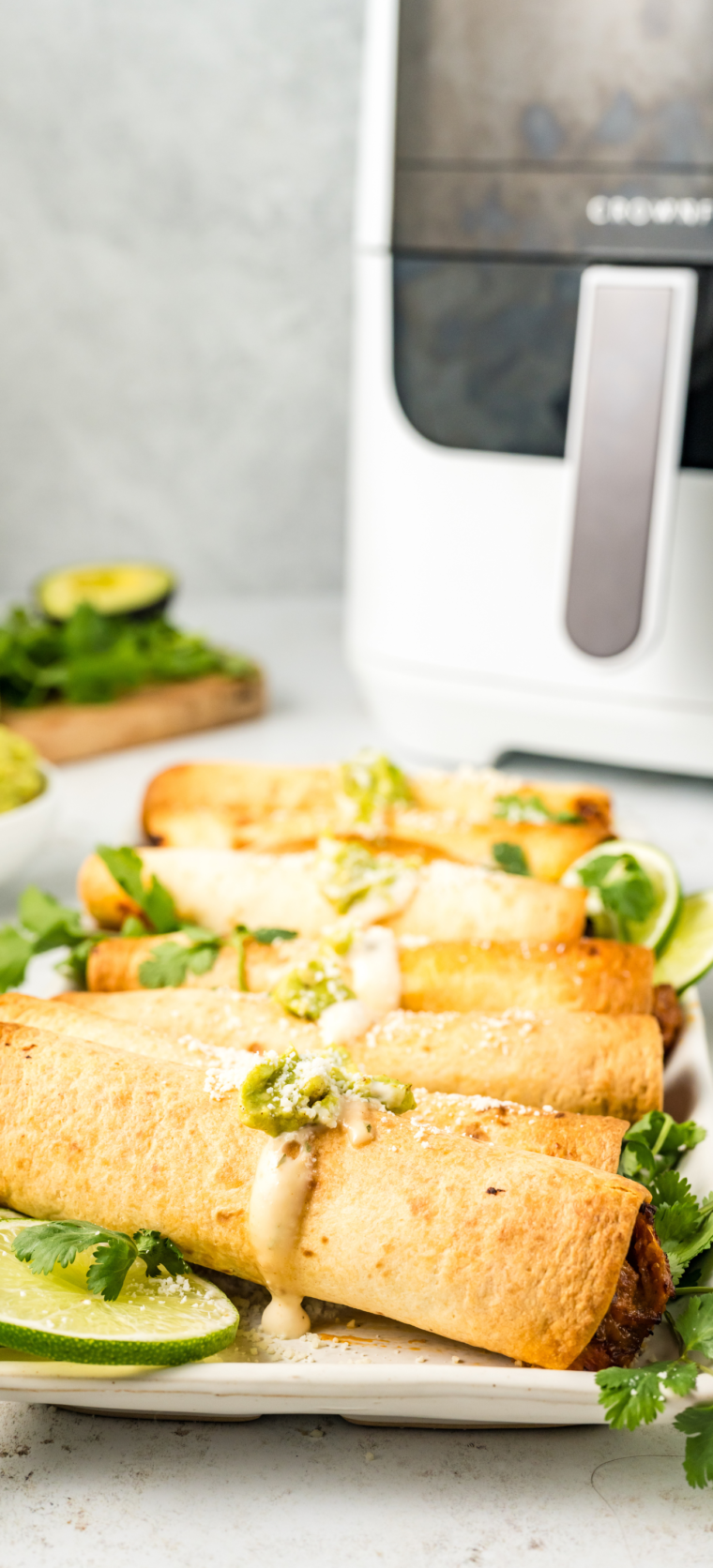 Plate of golden brown Air Fried Refried Bean and Veggie Flautas, ready to serve with dipping sauce.