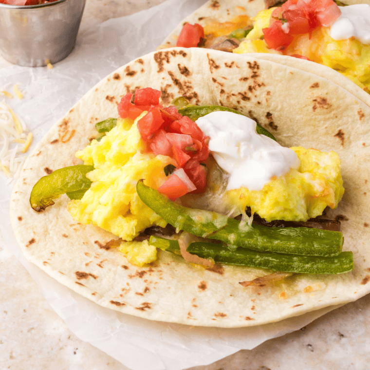 Air Fryer Breakfast Tacos filled with scrambled eggs, sautéed veggies, and melted cheese, served in flour or corn tortillas.