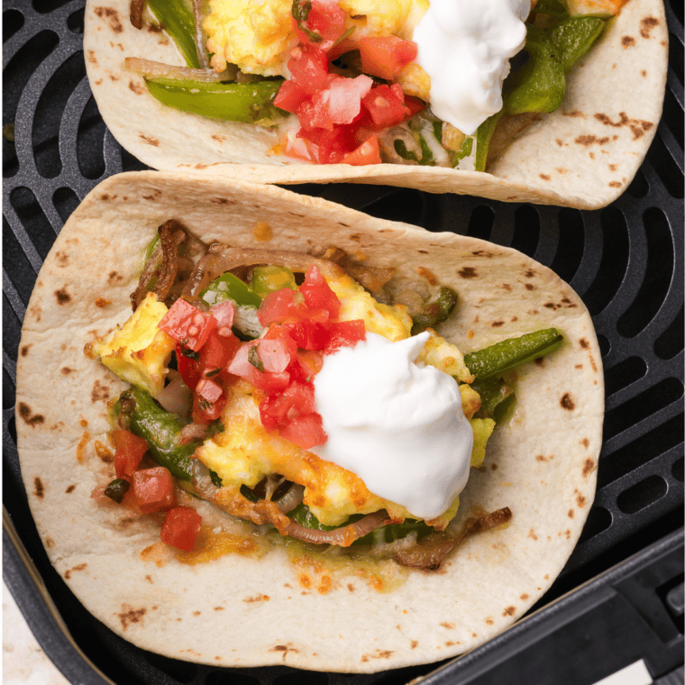 Air Fryer Breakfast Tacos filled with scrambled eggs, crispy bacon, and melted cheese, served in warm tortillas.