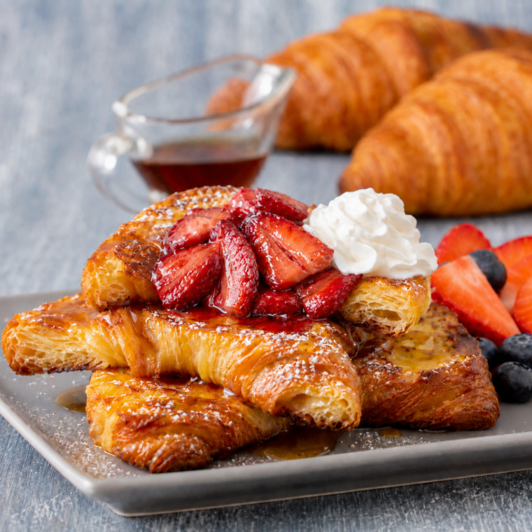 Air Fryer Croissant French Toast with Strawberries and whipped cream, served warm