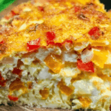 Wedge of fluffy air fryer frittata on a plate showing layers of bell pepper, onion, and cheddar