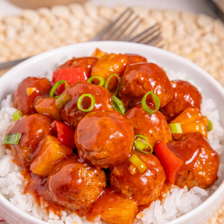 Air Fryer Honey Garlic Meatballs coated in glossy sauce, served on a white plate with toothpicks
