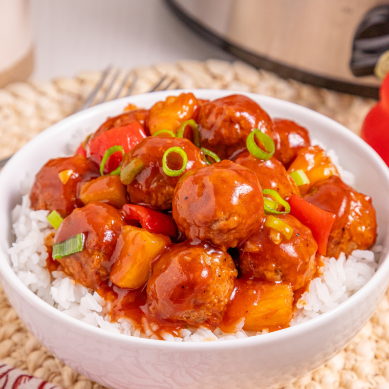 Air Fryer Honey Garlic Meatballs served over white rice in a bowl, coated in glossy honey garlic sauce