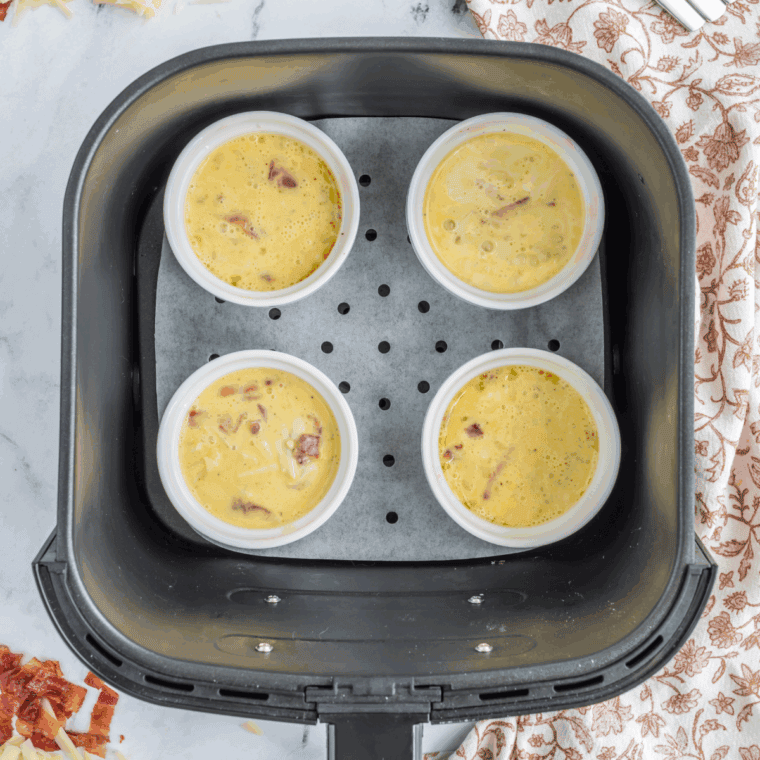 Air Fryer Scrambled Eggs in a Mug in the air fryer basket.