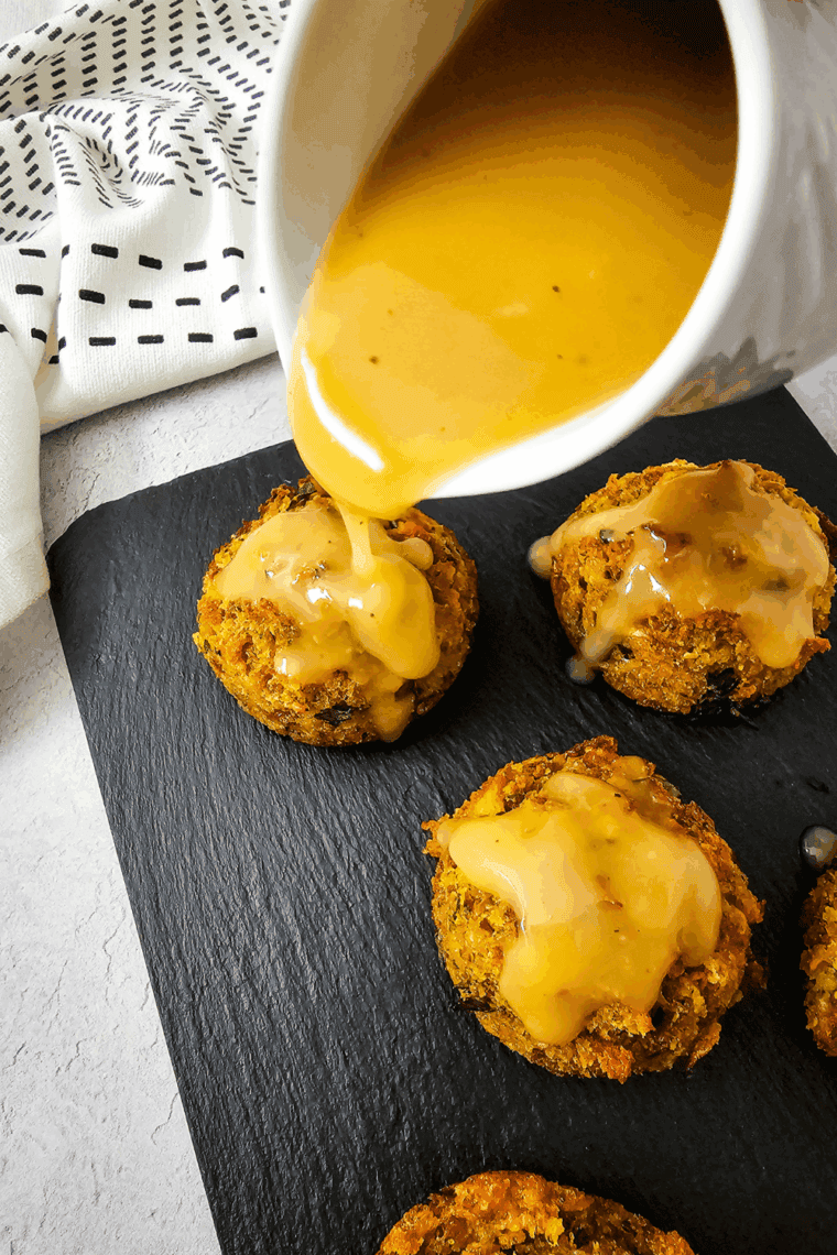 Individual servings of stuffing baked into muffin shapes, with a golden-brown crispy top, served on a platter.