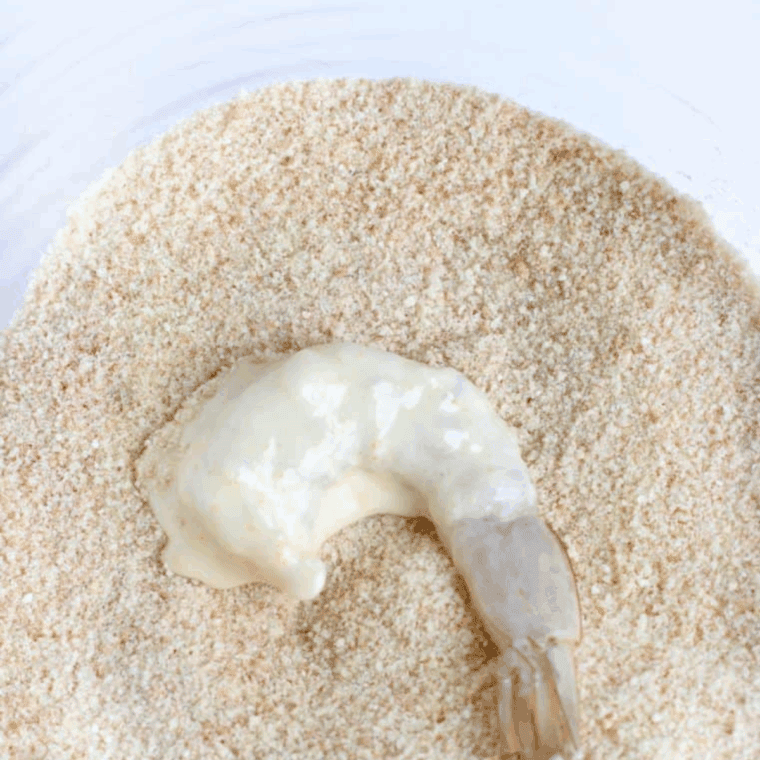 Small bowl filled with bread crumbs set aside for coating shrimp.
