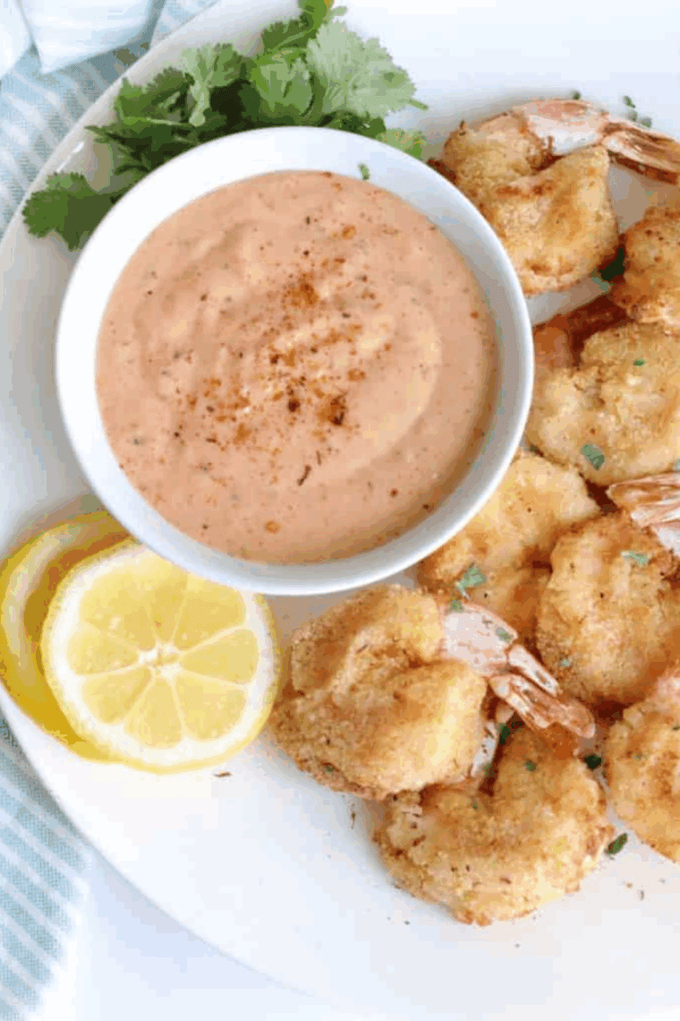 Golden, crispy Arthur Treacher’s fried shrimp served with tartar sauce on a plate.