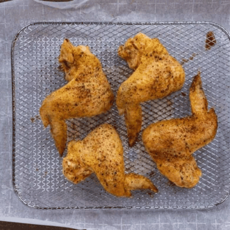 Crispy golden copycat Domino’s plain wings served on a plate with dipping sauce on the side.