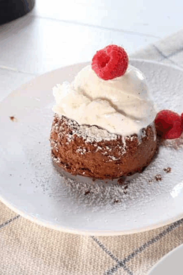 Close-up of Domino’s style chocolate lava crunch cakes with melted chocolate oozing out, served on a white plate.