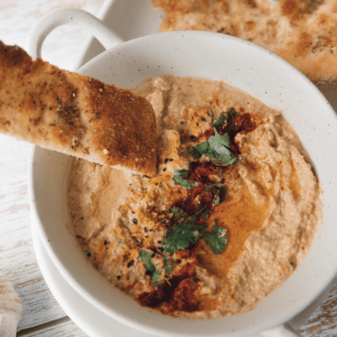 "Crispy baked pita chips seasoned with olive oil and spices served as a crunchy Mediterranean snack for dipping"