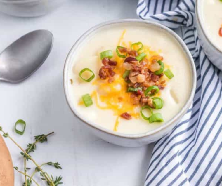 "Finished Instant Pot Chili’s Baked Potato Soup served in bowls with a creamy texture and garnished with sour cream and cheese."