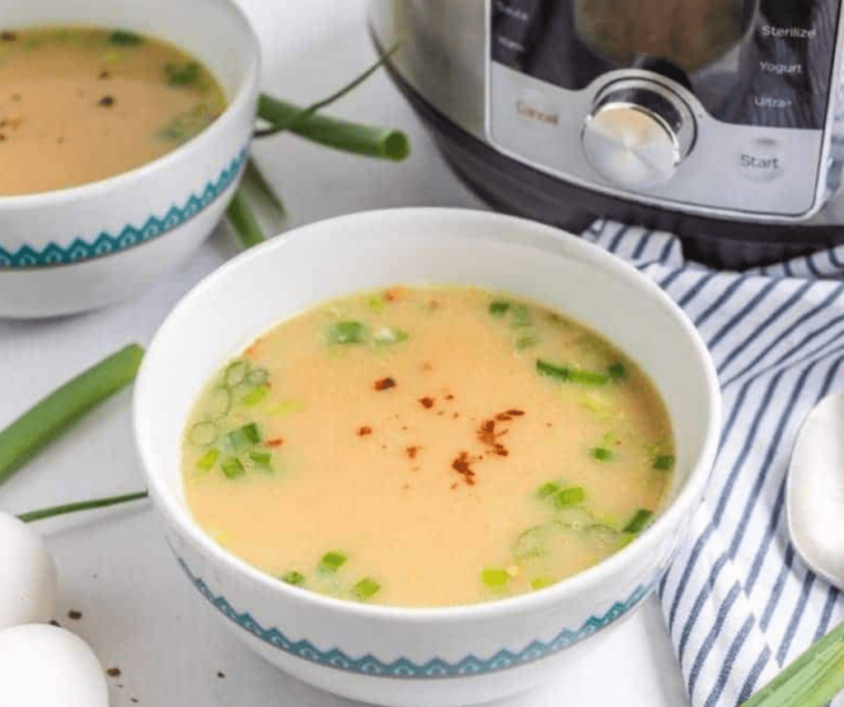 Bowls of Instant Pot Chinese Imperial Palace Egg Drop Soup garnished with green onions and a sprinkle of white pepper.