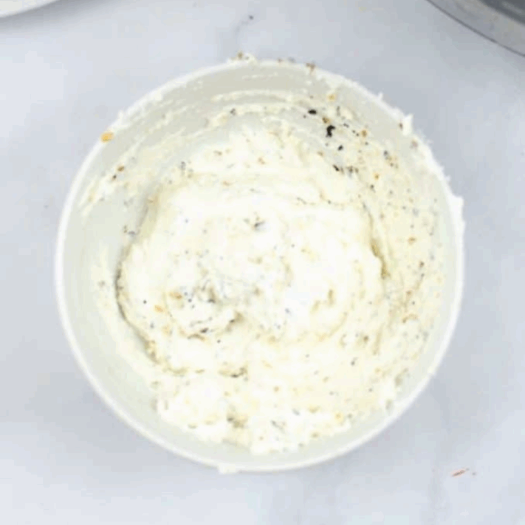 Mixing Everything But the Bagel seasoning, cream cheese, and red pepper flakes in a small bowl.