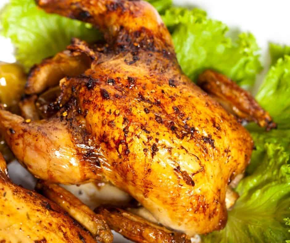 Cornish hen, cooked and on top of a bed of lettuce. 