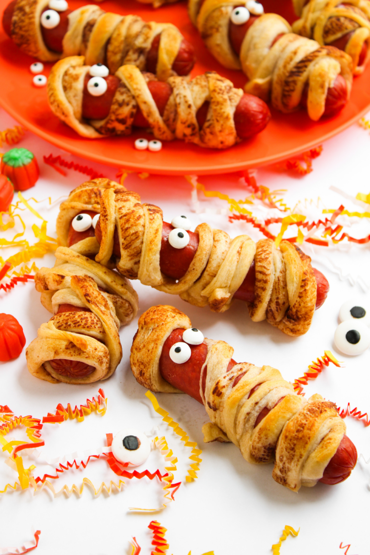 Air fryer mummy hot dogs wrapped in crescent dough with candy eyes, cooked until golden brown and crispy.