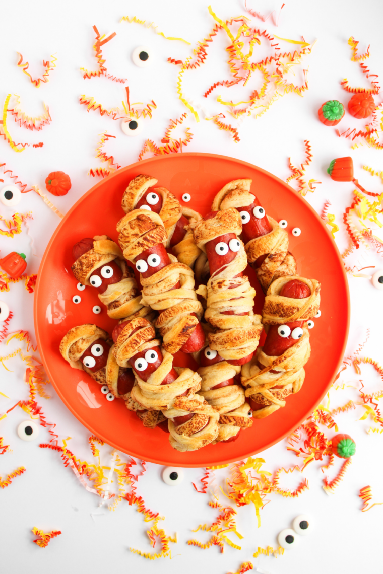 Air fryer mummy hot dogs wrapped in crescent dough with candy eyeballs, cooked until golden brown and crispy for Halloween.