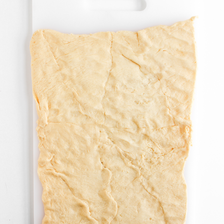 Hot dogs being dried thoroughly with paper towel before wrapping dough.