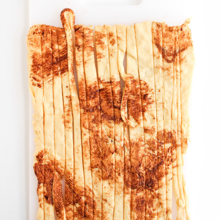 Crescent dough unrolled and cut into thin strips for mummy wrapping.