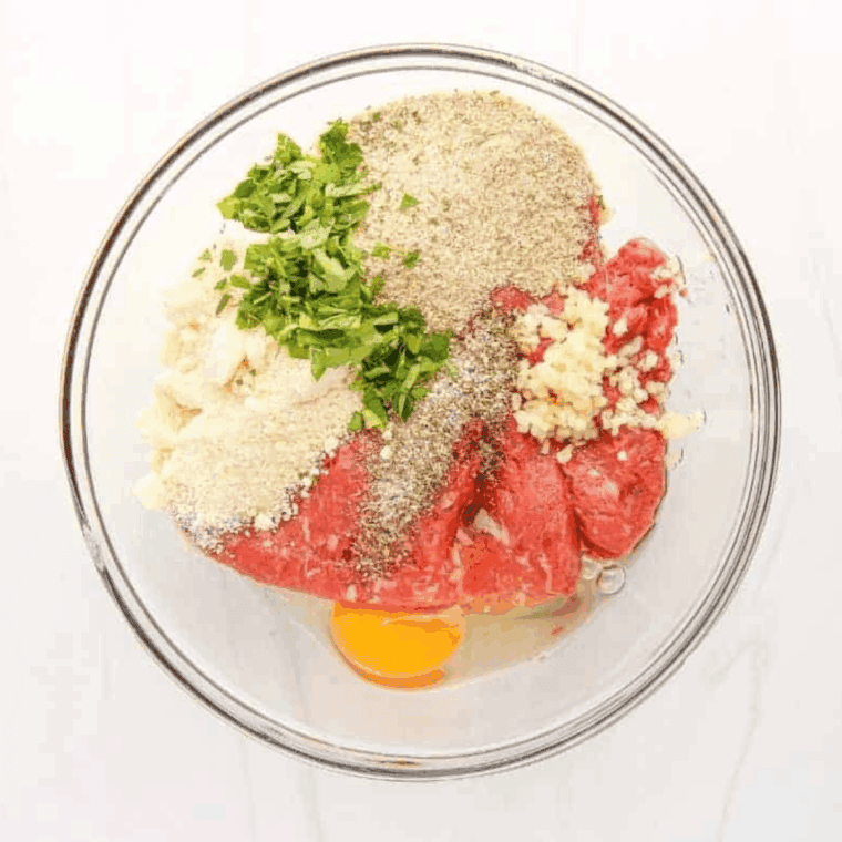 Mixing ground beef, pork, breadcrumbs, milk, eggs, Parmesan, garlic, parsley, salt, and pepper in a large bowl.
