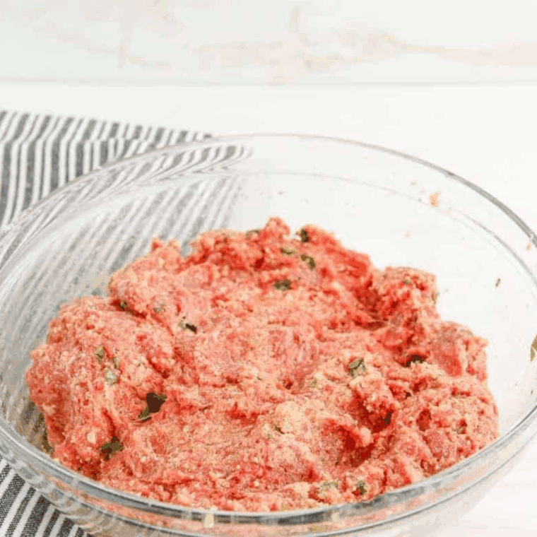 Formed meatballs placed evenly on baking sheet, ready to bake until golden brown.