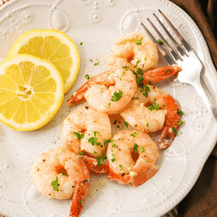 Sautéed shrimp in garlic butter sauce with lemon and parsley over pasta, inspired by Carrabba's Shrimp Scampi recipe.