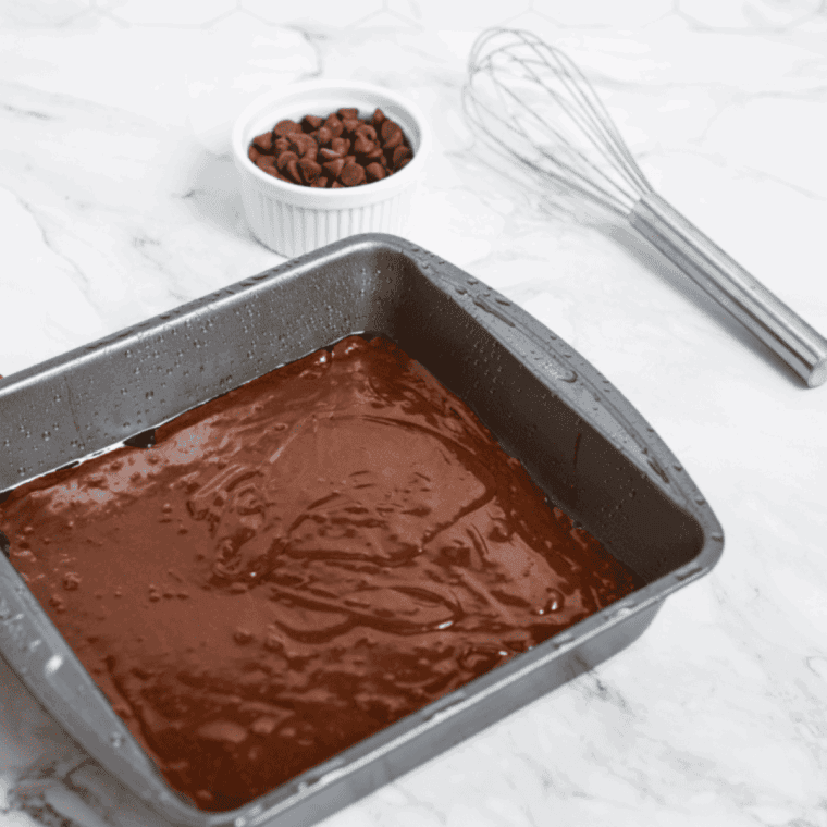 Pouring brownie batter into a greased pan and air frying until baked with fudgy center.
