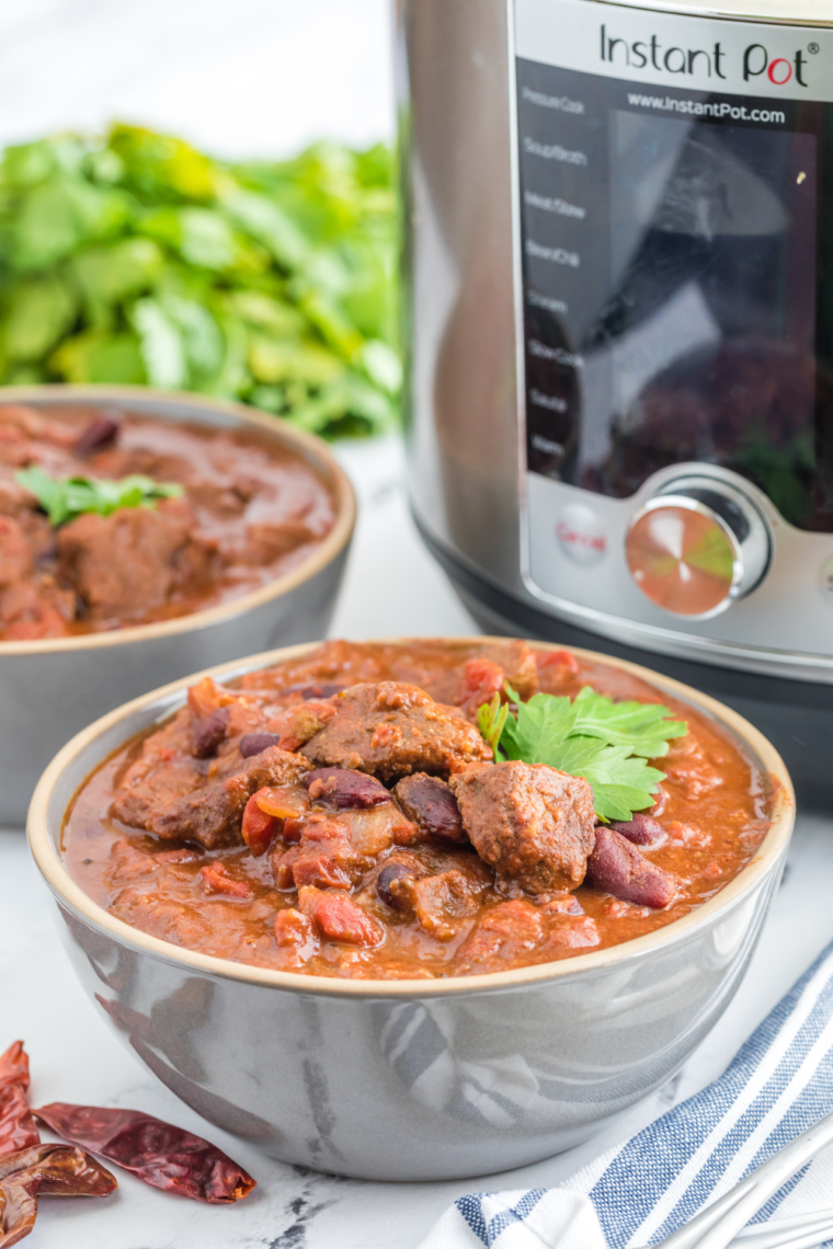 Close-up of a hearty bowl of Instant Pot Deer Chili with visible chunks of meat and beans."