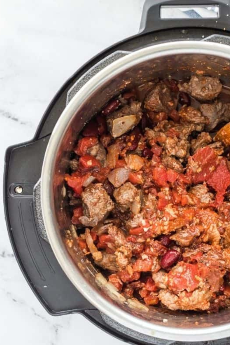 "Close-up of a hearty bowl of Instant Pot Deer Chili with visible chunks of meat and beans."