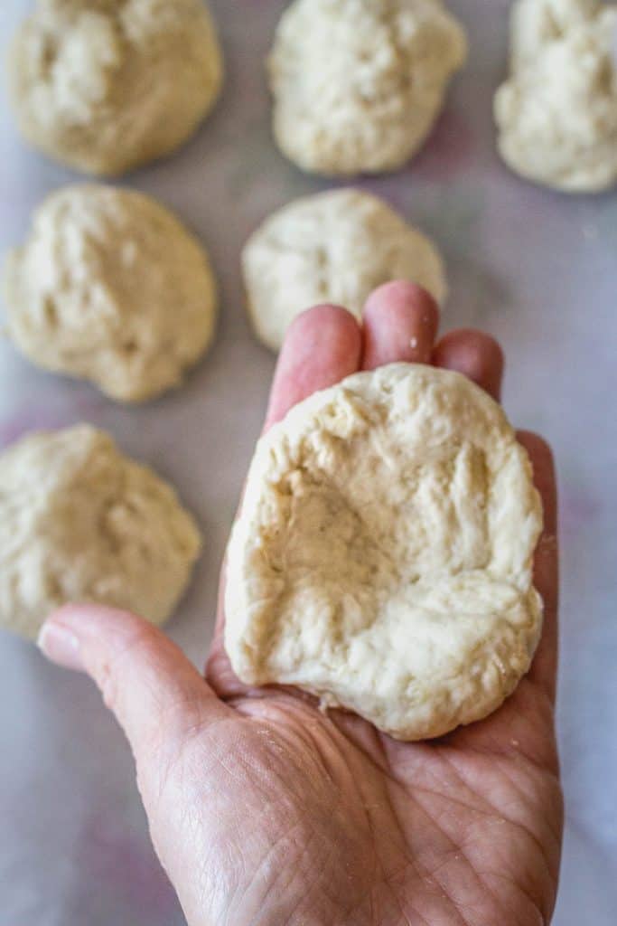 Divide the dough in 12 parts. Knead each part gently and then extend it on your hand. Wrap the sides, creating a roll with the wrapped size down. This step would make the bread puffier.