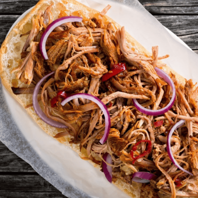 Fall-apart tender Instant Pot pulled pork sandwiches topped with BBQ sauce on toasted buns.