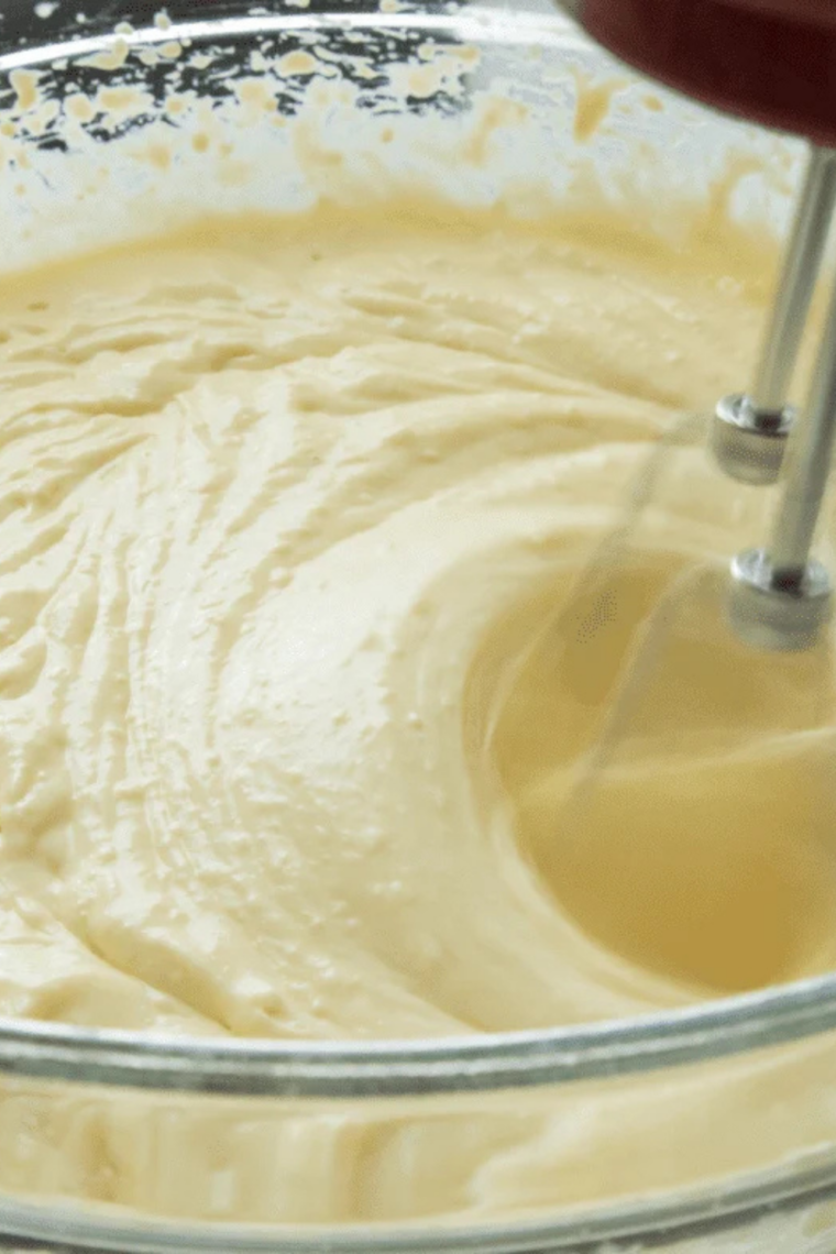 Cream cheese cheesecake batter being mixed until smooth and creamy