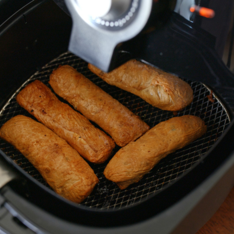 Air fryer basket with golden-brown fries, showcasing common air fryer mistakes to avoid.