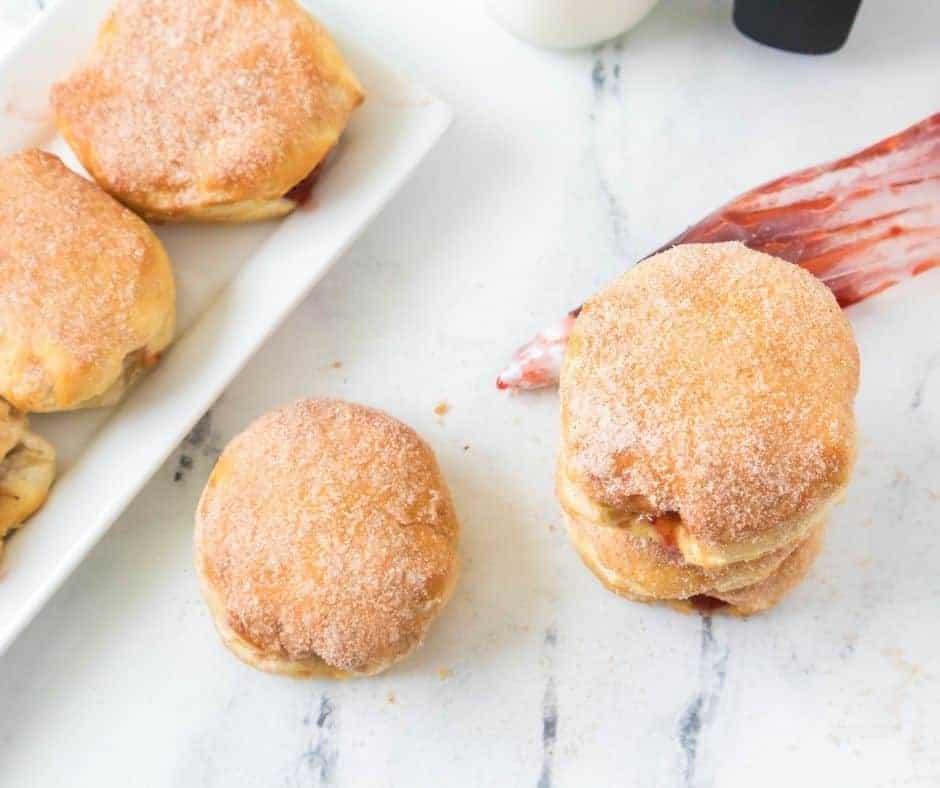 overhead: air fryer biscuit donuts with a jelly injector visible