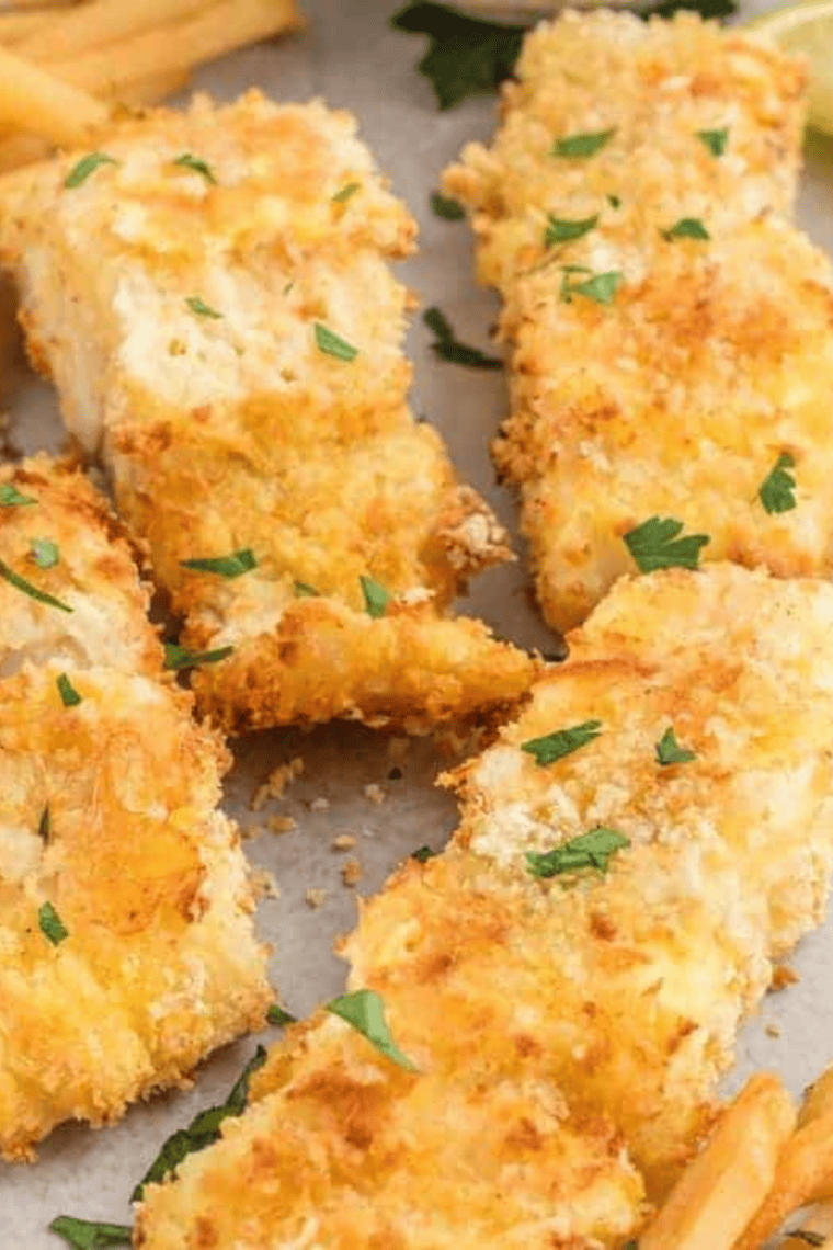 Plate of breaded salmon with a side of vegetables and a lemon wedge